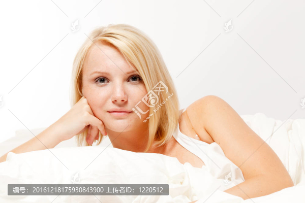 躺在床上的美麗微笑的年輕女子