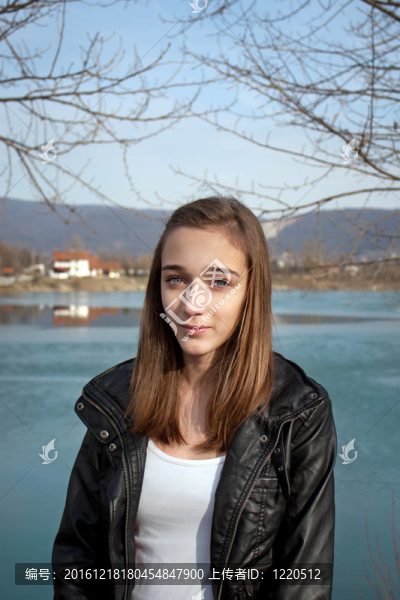 十幾歲的女孩穿著黑色皮夾克在湖邊
