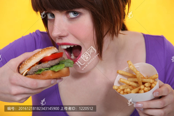 女人吃漢堡包和薯條