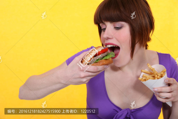 女人吃漢堡包和薯條