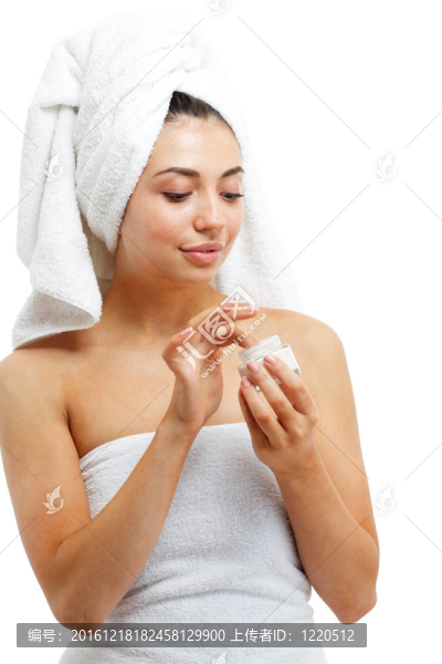漂亮女性在臉上涂潤膚霜。