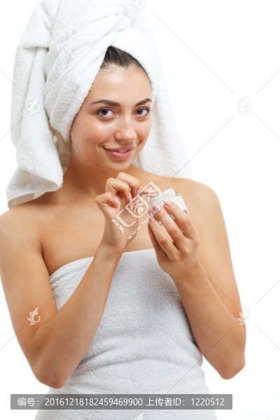 漂亮女性在臉上涂潤(rùn)膚霜。