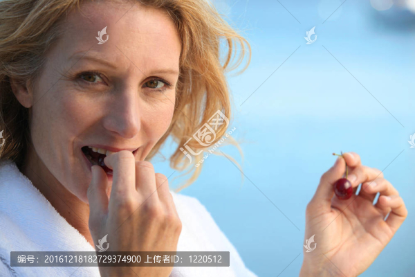 成熟的金發(fā)女人吃櫻桃