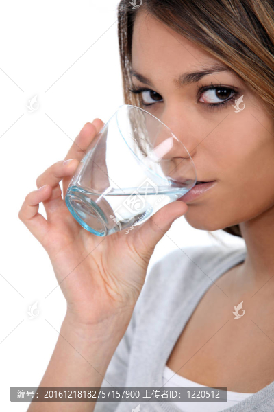 一個(gè)美麗的女人喝一杯水。