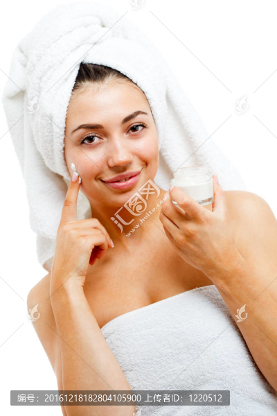 漂亮女性在臉上涂潤膚霜。