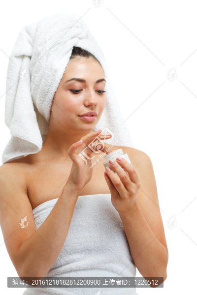 漂亮女性在臉上涂潤膚霜。