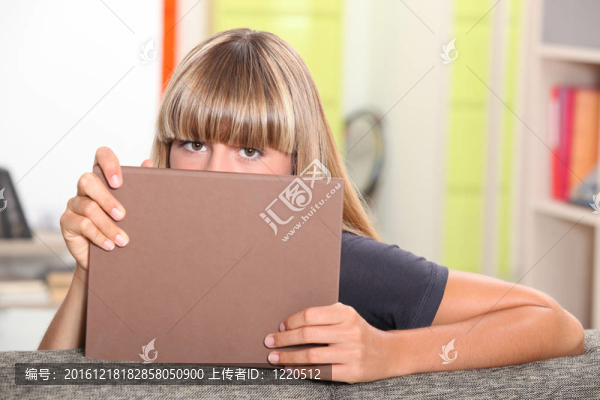 少女躲在書后。