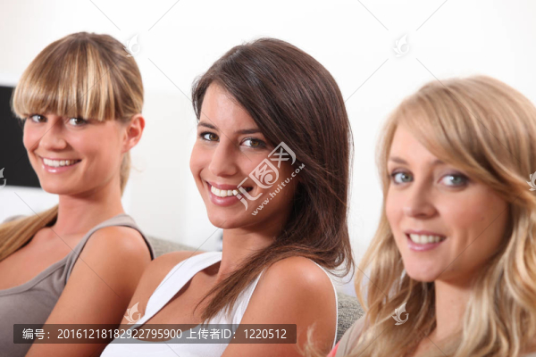 三個(gè)漂亮的年輕女人坐在沙發(fā)上
