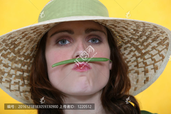 女人在她的嘴唇和鼻子之間平衡一顆青豆