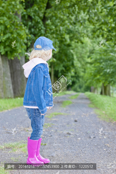 春天小巷里穿著小靴子的小女孩