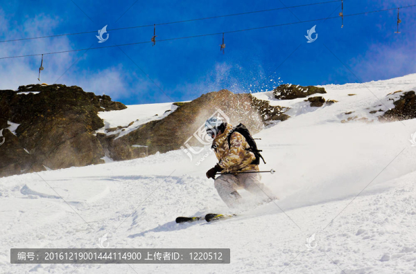 在厚厚的雪地上滑雪。在懸崖的背景下。養(yǎng)雪塵。