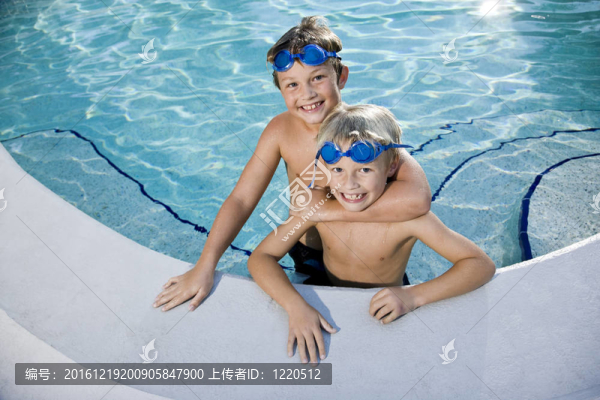 夏天的樂趣；男孩在游泳池里玩耍