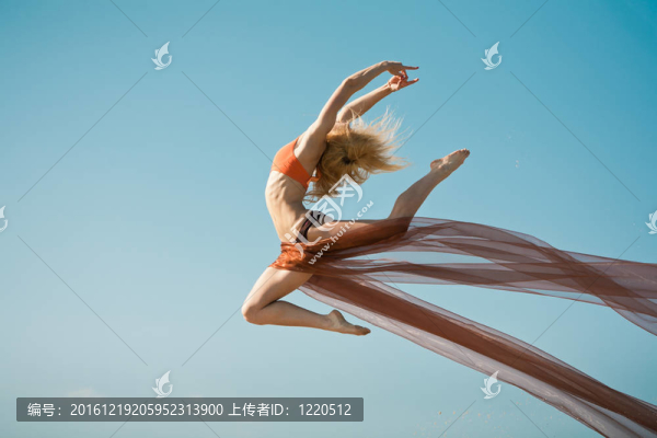 女孩用橙色大布跳舞