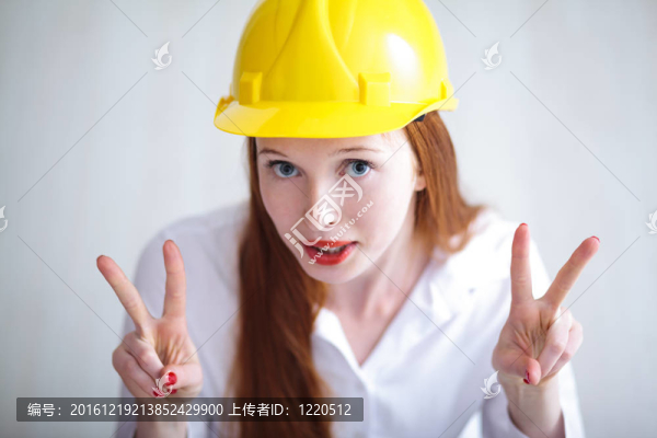 年輕美麗的女性與黃色頭盔顯示和平標(biāo)志