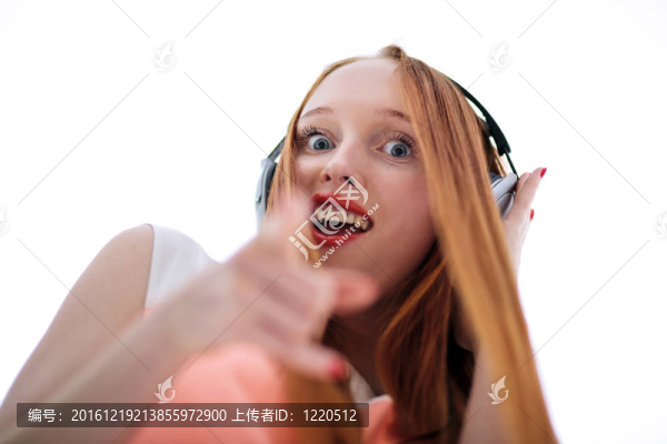 帶耳機(jī)聽(tīng)音樂(lè)的紅頭女人