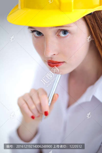 年輕漂亮的女性拿著黃色頭盔拿著筆