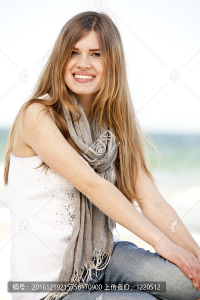 有趣的少女坐在海邊。