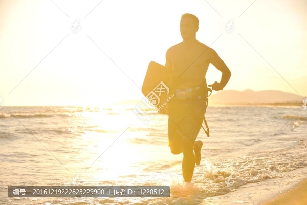 一個(gè)年輕人在海灘上的日落kitsurf肖像