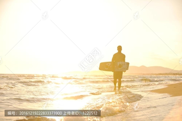 一個年輕人在海灘上的日落kitsurf肖像