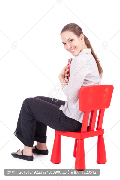 坐在紅色的；孩子的椅子年輕女子