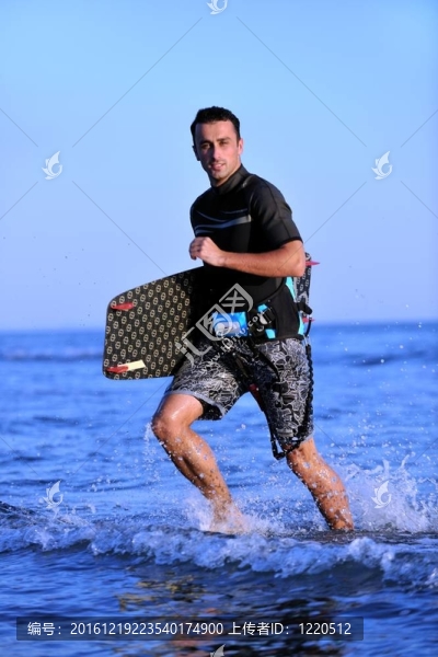 一個年輕人在海灘上的日落kitsurf肖像