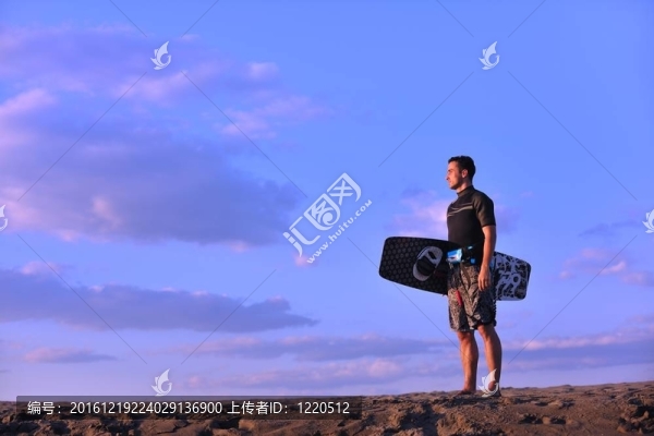 一個(gè)年輕人在海灘上的日落kitsurf肖像