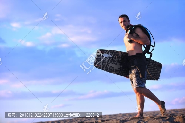 一個年輕人在海灘上的日落kitsurf肖像