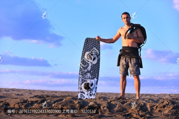 一個年輕人在海灘上的日落kitsurf肖像