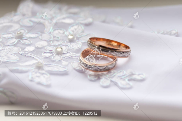 白色背景手套上的結(jié)婚戒指。
