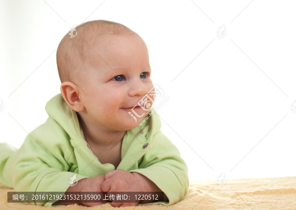 美麗的三個月大的男孩穿著綠色的衣服