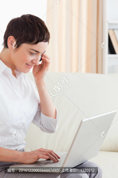 迷人的短發(fā)女人與筆記本電腦和電話