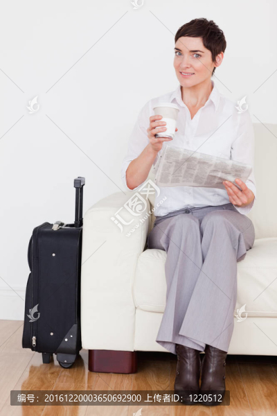 黑發(fā)女人與一個(gè)手提箱；報(bào)紙和一杯