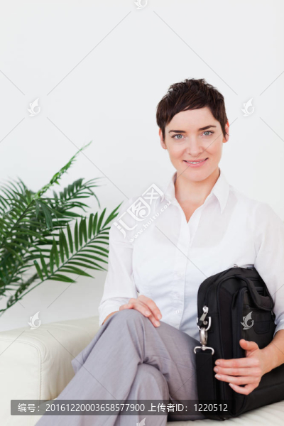 短頭發(fā)的微笑的女商人坐在沙發(fā)上