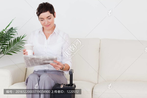 帶著手提箱的短發(fā)的迷人女人；在候車室里的報(bào)紙和杯子