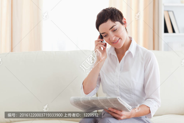 微笑的黑發(fā)女人用手機(jī)瀏覽報(bào)紙