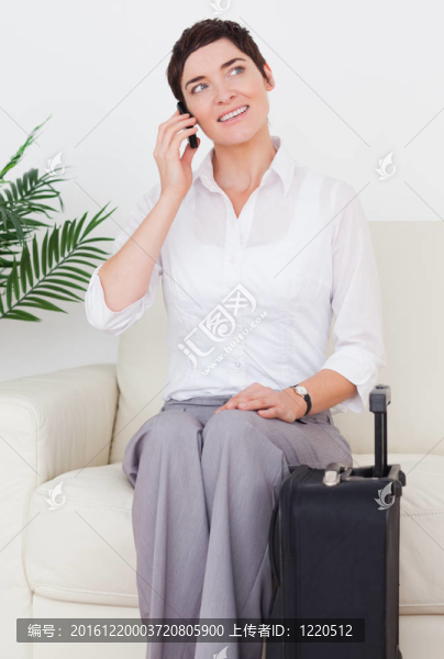 漂亮的女人帶著手提箱和電話