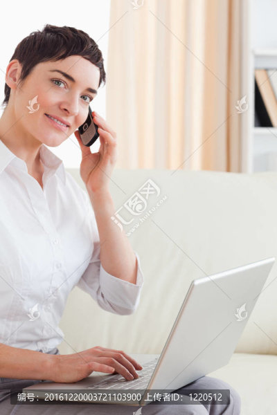 帶筆記本電腦和電話的短發(fā)女人