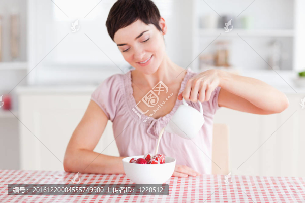 女人澆奶油超過草莓