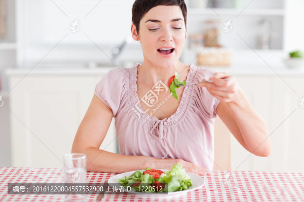 微笑的黑發(fā)女人吃沙拉