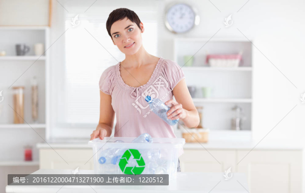 可愛的女人把瓶子放在回收箱里