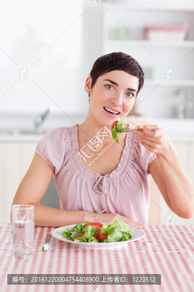 開朗的黑發(fā)女人吃沙拉