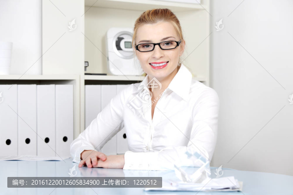坐在桌子后面的微笑女人。