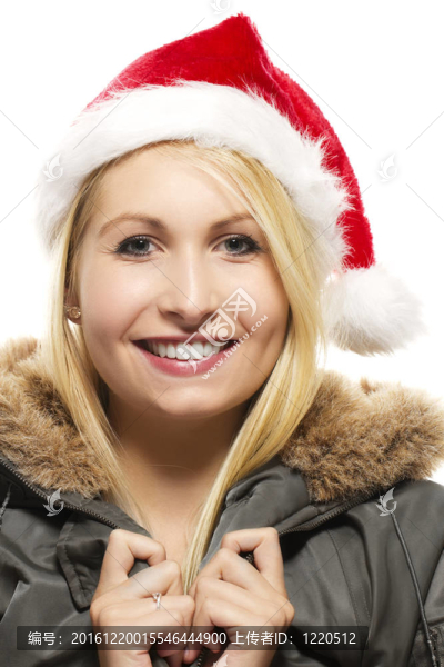 美麗的金發(fā)女人笑著大衣戴著圣誕帽的白色背景