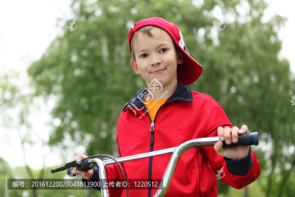在綠色公園騎自行車的男孩