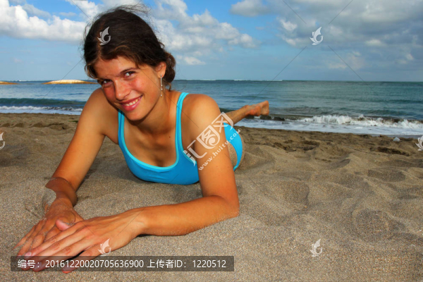 快樂的年輕女子躺在沙灘上