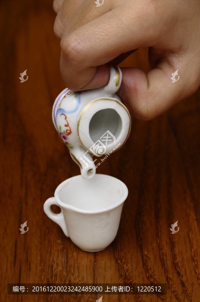 小孩用手在茶杯里倒茶