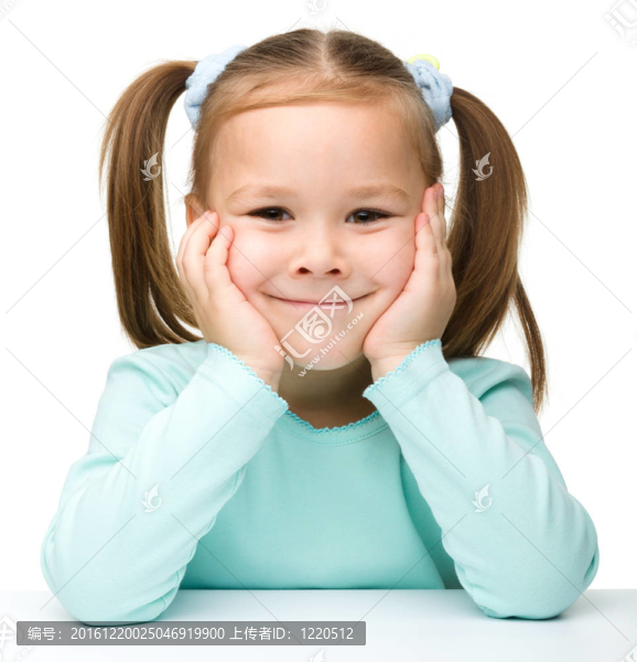 快樂的小女孩坐在桌子旁微笑