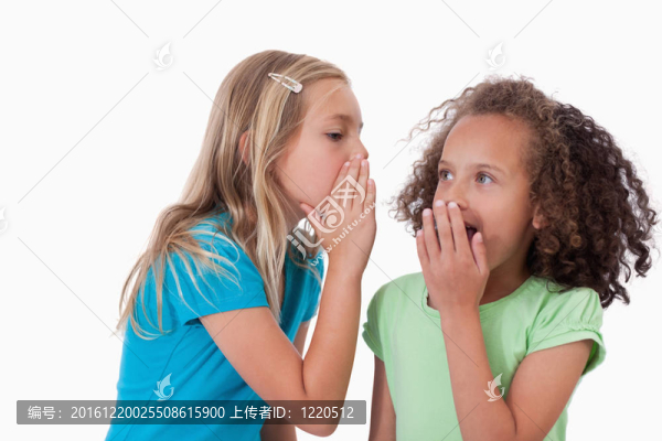 可愛的女孩向朋友耳語秘密