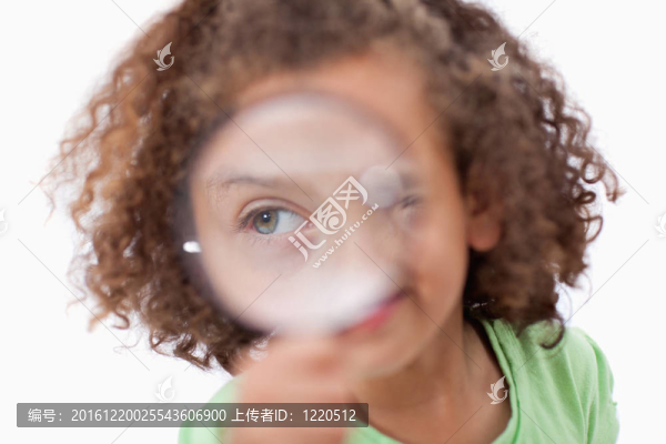 微笑的女孩透過放大鏡看