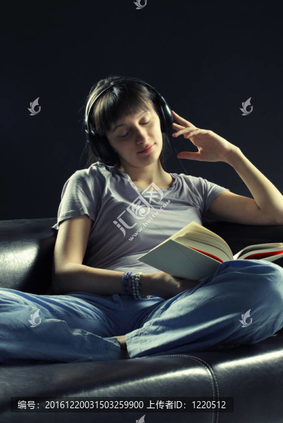 放松的年輕女性聽音樂和看書